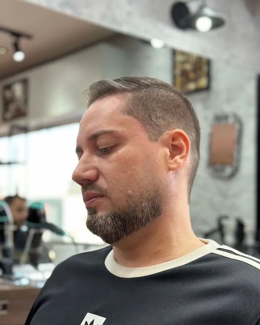 Cliente com laterais curtas e barba aparada, feito na Fino Trato