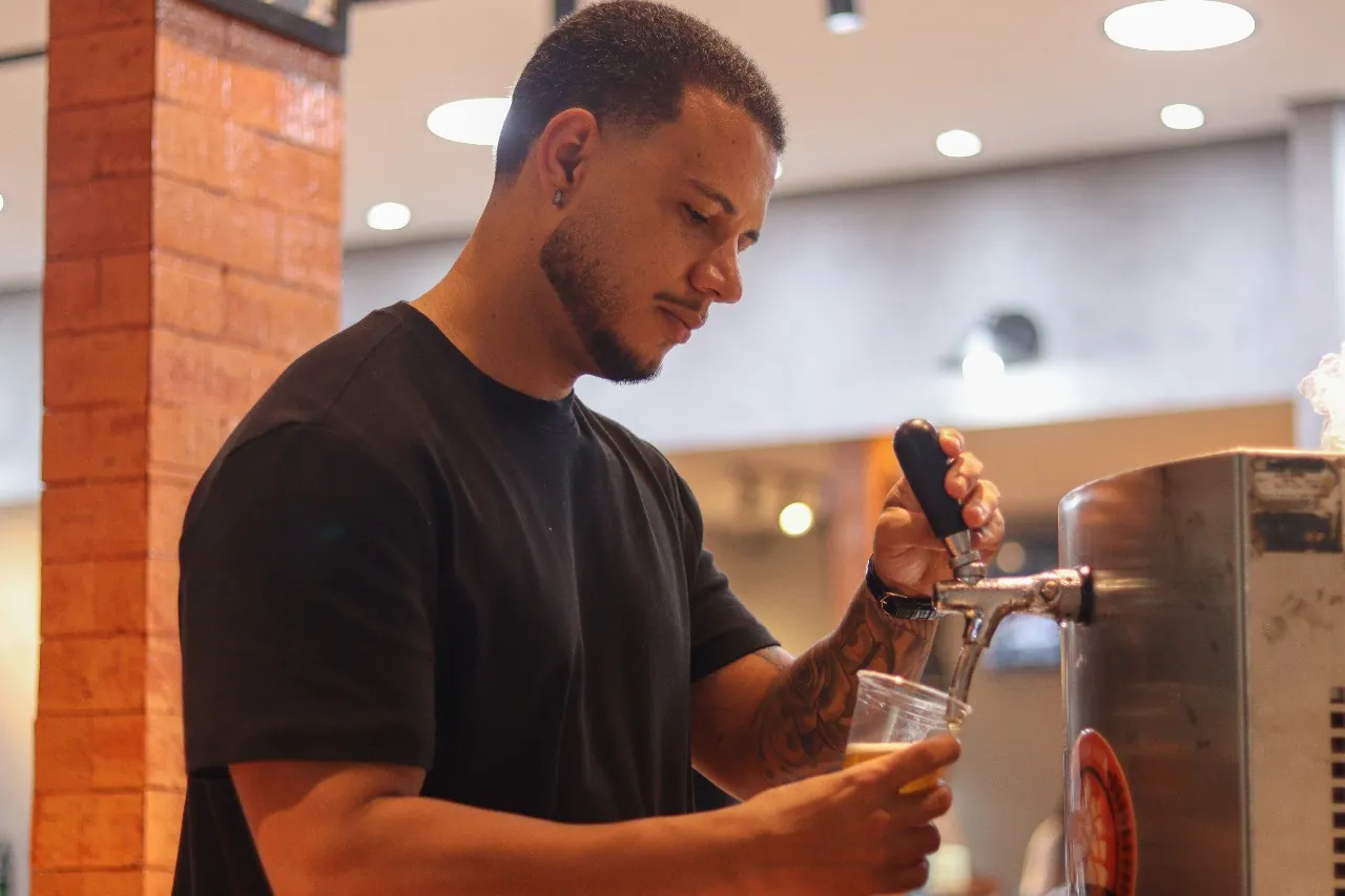 Convidado servindo chope durante a inauguração